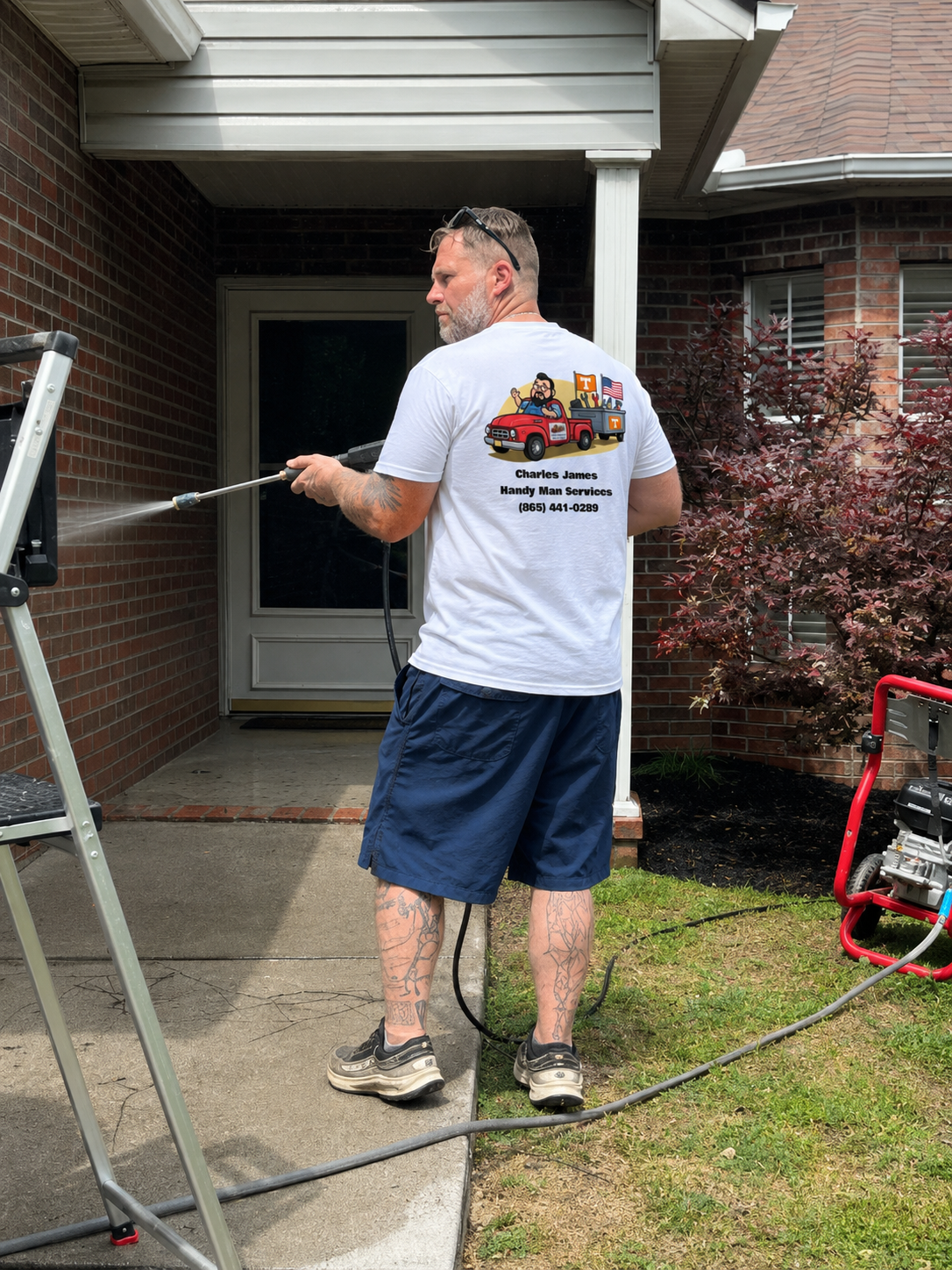 Crew member pressure washing a home